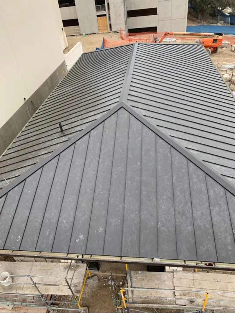 Commercial metal roof construction with crane equipment in Olivette